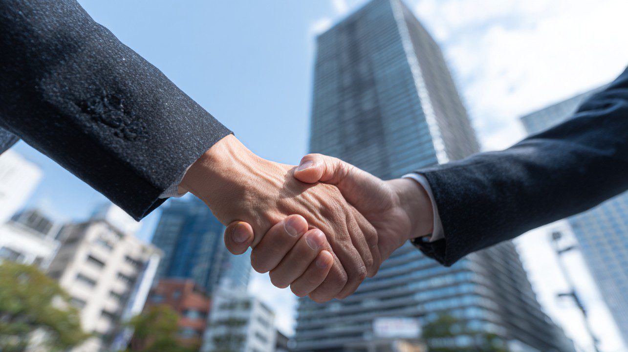 Business Handshake Close-Up with City Background