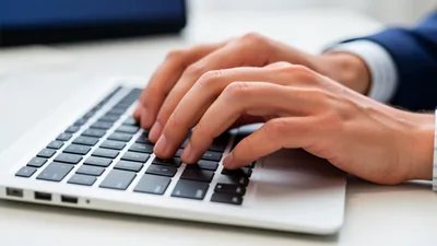 Blog Close Up of a Persons Hands Typing on a Keyboard